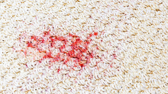 Photo of red stain on white carpet